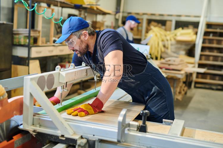 年轻的家具工人正在修理木板照片摄影图片